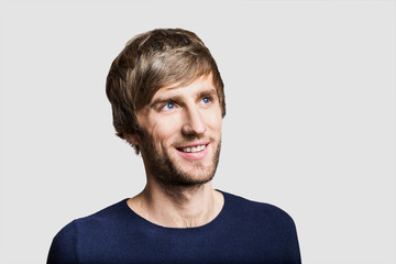 Naklejka premium Handsome smiling young man looking away. Studio shot