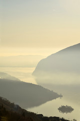 An suggestive view of Lake Iseo at sunset with the fog