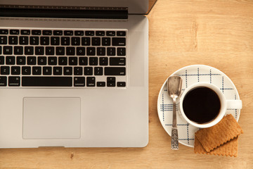 Computer with cup of black coffee and empty notebook to make plans for holidays. 