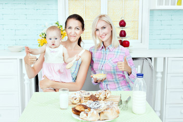 Obraz na płótnie Canvas Pretty woman in the kitchen with the baby.