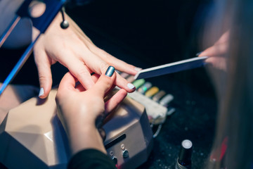 Manicure set in a beauty salon. Beautiful female hands