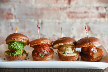 Meatball burgers in a row on serving dish