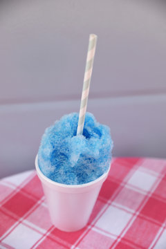 Blue colour snow cone in disposable cup with straw
