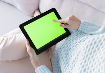 Woman at home relaxing reading on the tablet computer