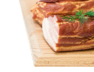 Smoked pork with spices on a wooden board isolated on white background.