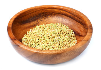 Wooden bowl with of green buckwheat isolated.