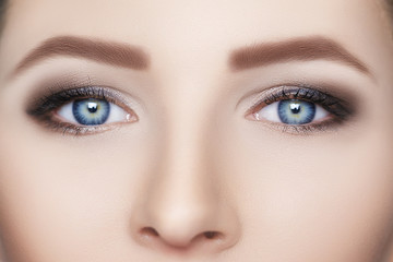 Close-up of blue woman eye and beautiful eyebrows