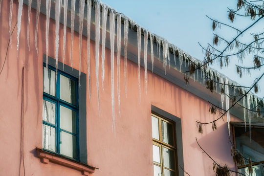 Icicle on the roof. Winter sunny day. Vivid splittoned image.
