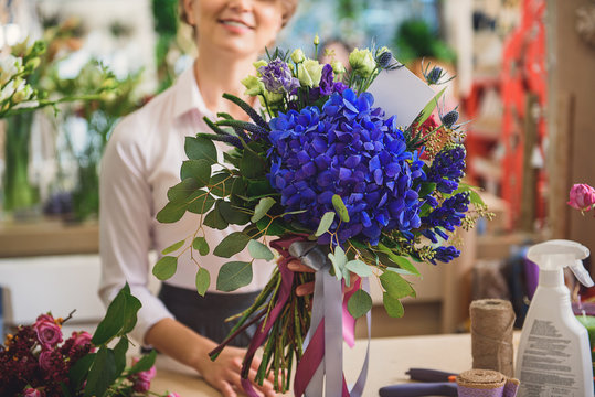 Happy female florist selling wonderful bouquet