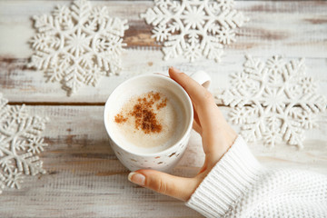 Obraz na płótnie Canvas Holding warm coffee on a winter day. Woman hands. Top view