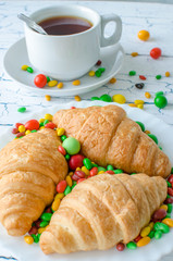 Tea on the table with croissants and scattered caramel