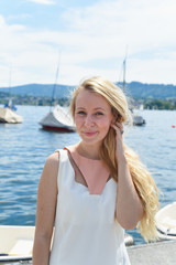 Fototapeta na wymiar Happy young woman in dress on the lake in Zurich, Switzerland