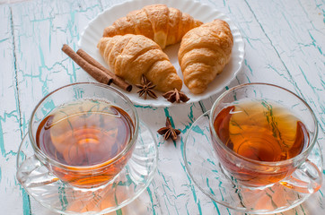 Tea on the table with croissants and spices