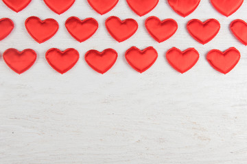 Red hearts on a white wood background