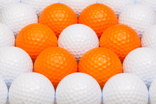 White and orange golf balls in the box