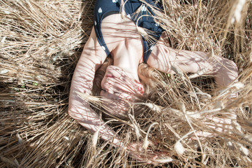 Beautiful freckled blonde woman lying in wheat field, natural fresh skin