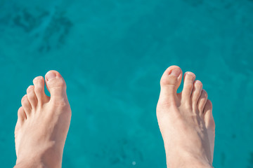 man feet on sea background