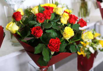 Beautiful bouquet of red and yellow roses at floral shop, closeup