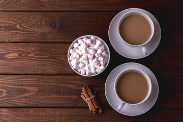 Top view of Two cups of coffee with milk or hot cocoa, plate with marshmallows 