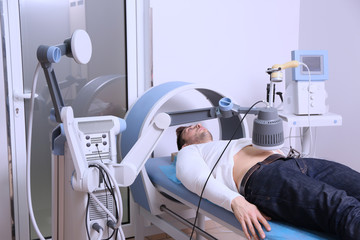 Inductive shortwave diathermy for young man in modern clinic