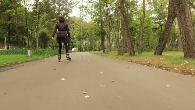 Inline skates. Dark-haired stylish woman moving on roller skates. The view from the back. 4K