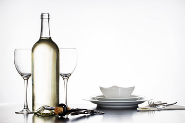 Korkenzieher mit Naturkorken vor Weinflasche, Glas und Geschirr
