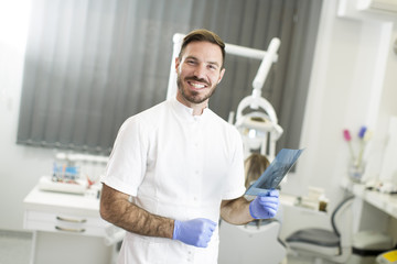 Naklejka na ściany i meble Dentist analyzing x-ray of teeth
