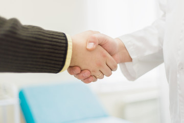 Obraz na płótnie Canvas Doctor hand shaking with man in hospital