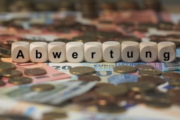 abwertung - Holzwürfel mit Buchstaben im Hintergrund mit Geld, Geldscheine
