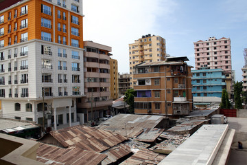modern high rise apartments next to iron sheet huts in downtown Dar Es Salaam, Tanzania, East Africa