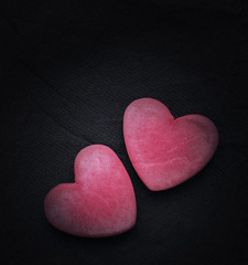 Fototapeta premium Two red hearts on a dark background, soft focus. Romantic card. Declaration of love in vintage style. Gift by St. Valentine's Day.