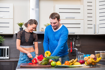 Young couple having fun in the kitchen preparing dinner