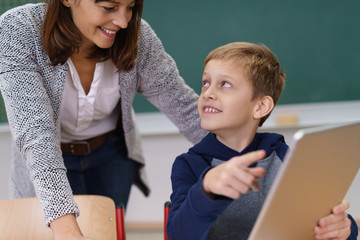 schüler zeigt seiner lehrerin etwas am tablet