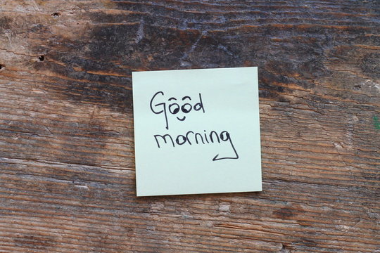 Message Good morning with smiley face on wooden table 