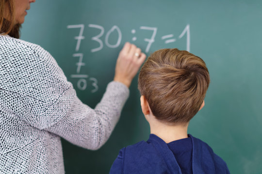 lehrerin und sch&uuml;ler rechnen an der tafel