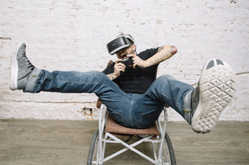 Obraz premium Young man using an VR glasses while playing videogames