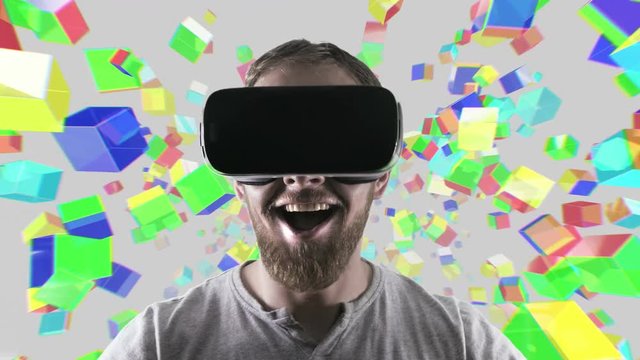 Emotional smile happy man wearing virtual reality goggles. VR headset. Within virtual space cubes white