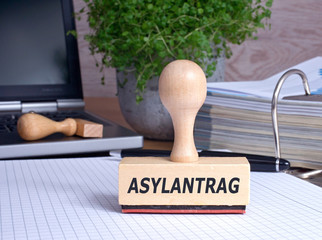 Asylantrag Stempel im Büro mit Ordner und Laptop