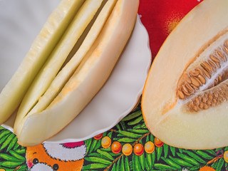  plate with a few slices of ripe melon and a portion of the cut melon