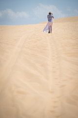 Young female walking in a desert, Vietnam. White sand dune in Mui Ne, Vietnam