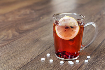 Herbal tea with lemon and pills . Healthcare Concept