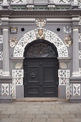 An ancient house in the old town centre. It differs from other houses unusual coloring and stucco above the doors. 