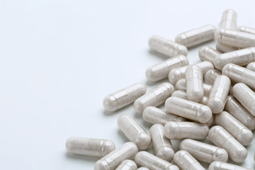 Heap of white capsules medications on white background. Copy space. High resolution product. Health care concept