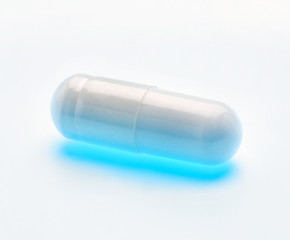 One glowing capsule, isolated on white background. Close up, high resolution product. Health care concept