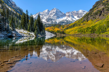 Maroon Bells in Autumn - Autumn view of snow coated Maroon Bells reflecting in crystal clear Maroon...