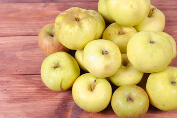 Green apples in a heap on the wooden surface
