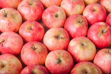 A bunch of red apples on an old wooden board