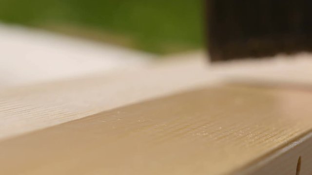 4K footage. Close-up paintbrush varnishing wooden plank