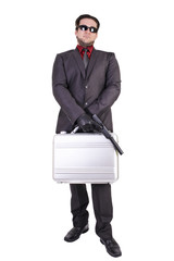 Handsome man holding gun and suitcase, isolated on white background.
