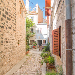 Fototapeta na wymiar Narrow street and old houses in old town in Cres, Croatia, Mediterranean ambient 